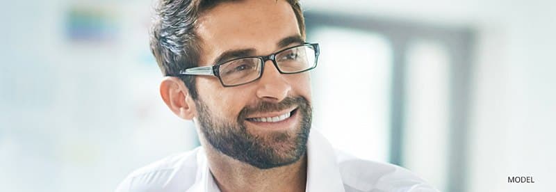 Man with brown hair and glasses smiling
