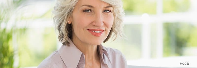 Woman with white hair wearing collared shirt smiling
