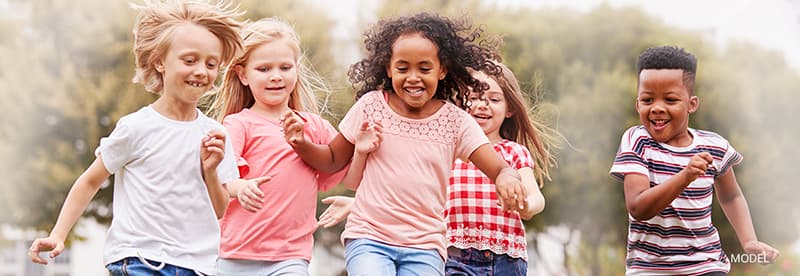 Group of five children running and smiling