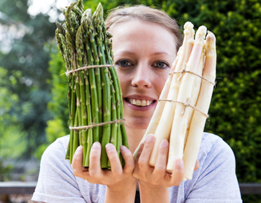 Woman holding asparagus.