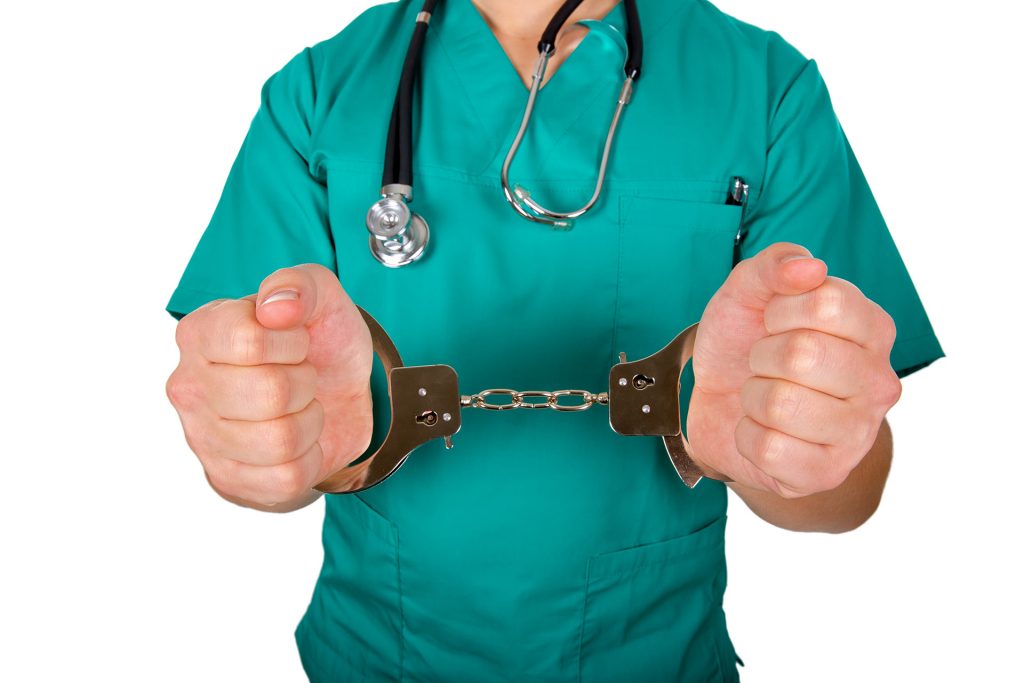 Man in scrubs and handcuffs.