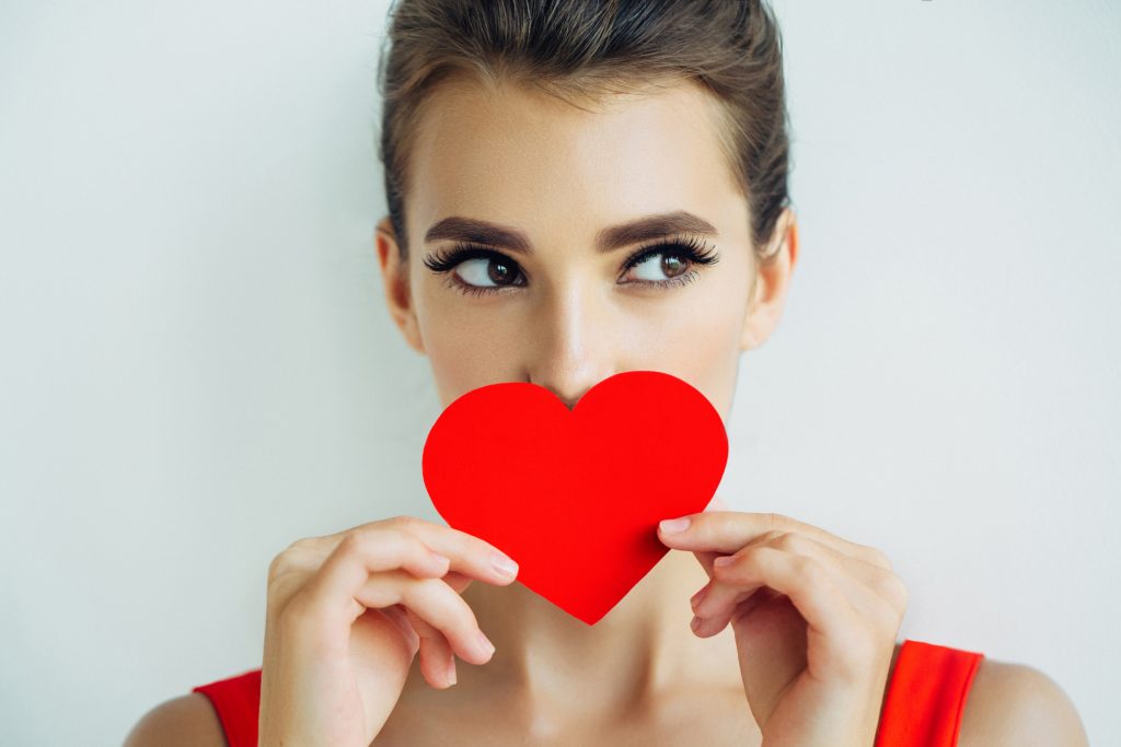 Woman with red heart over her mouth.