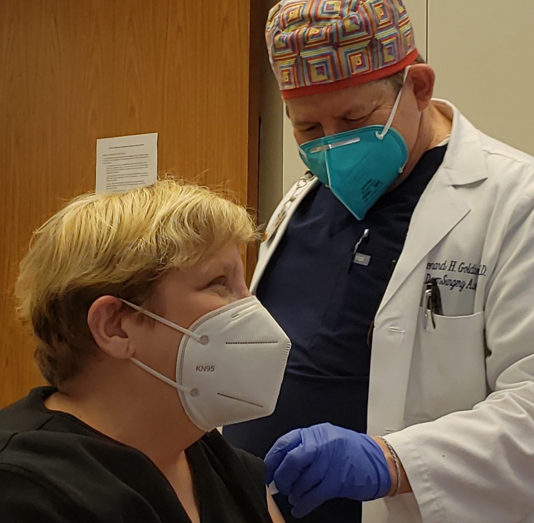 Dr. Leonard Goldberg administers the COVID-19 vaccine to Dr. Esta Kronberg.