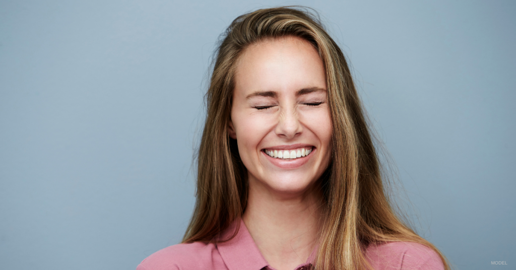 Young woman squinting her eyes closed.