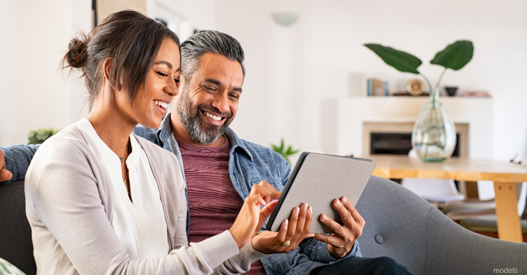 man and woman take the DermSurgery laser quiz on a tablet (models)