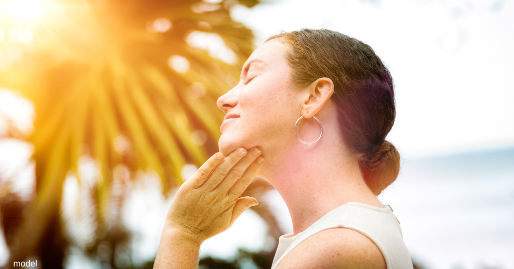 Woman in the sun feeling the effects of uv damage (model)