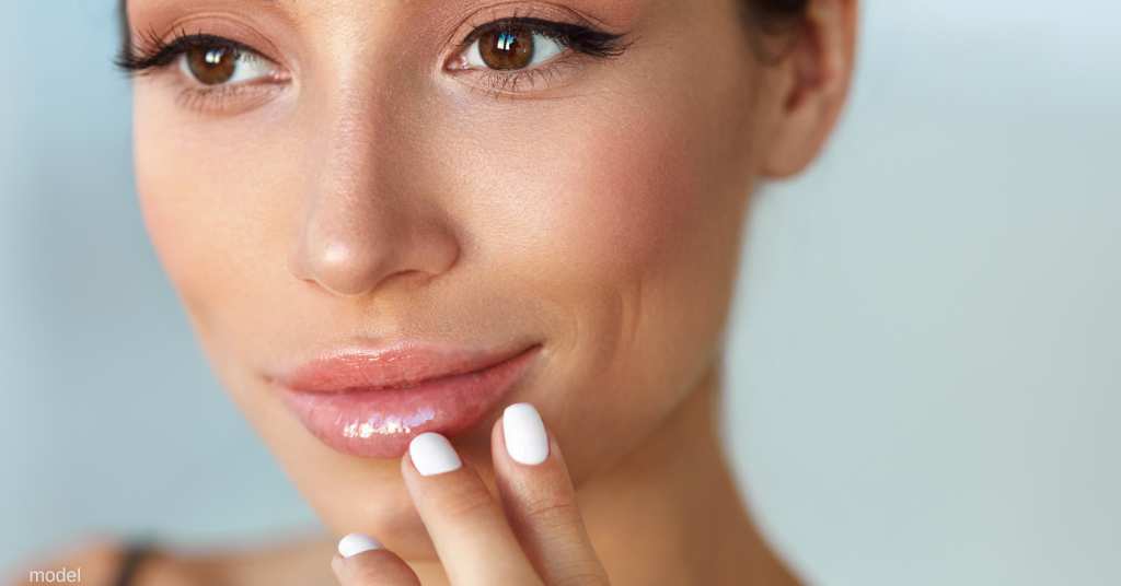 Woman touching her lips and smiling (model)