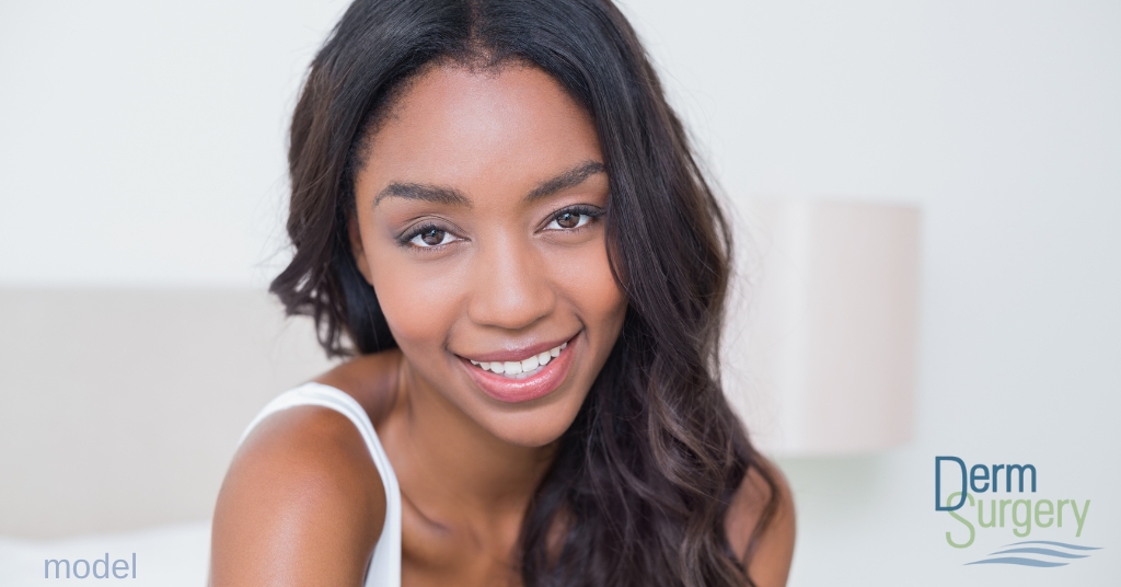 Beautiful woman smiling after receiving microneedling treatment.