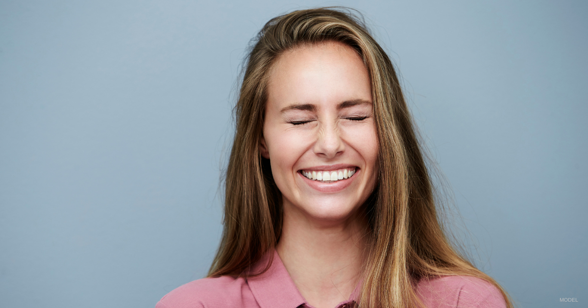 Young woman squinting her eyes closed.